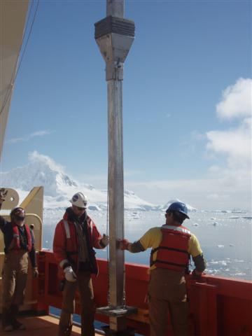NBP crew handles coring instrument on ship.