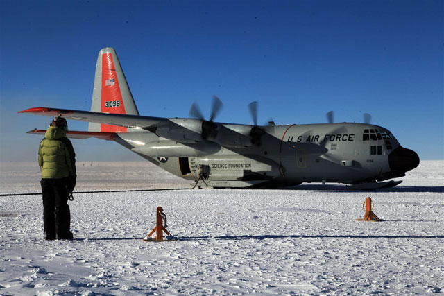 Plane on ice with person in foreground.