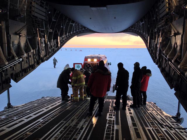 People inside a plane await a patient offload.