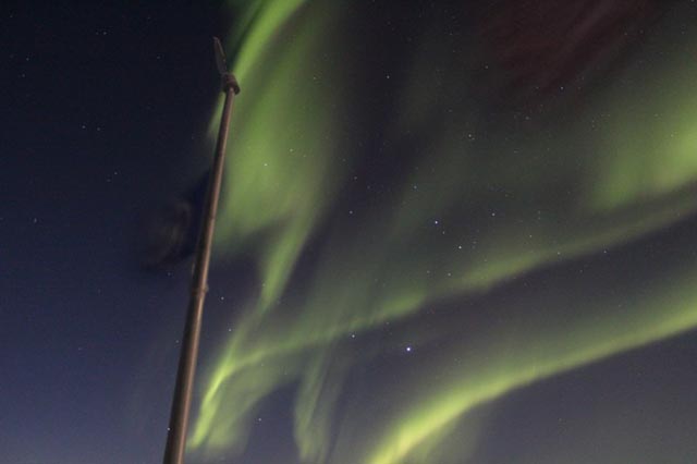 An aurora shines in the night sky.