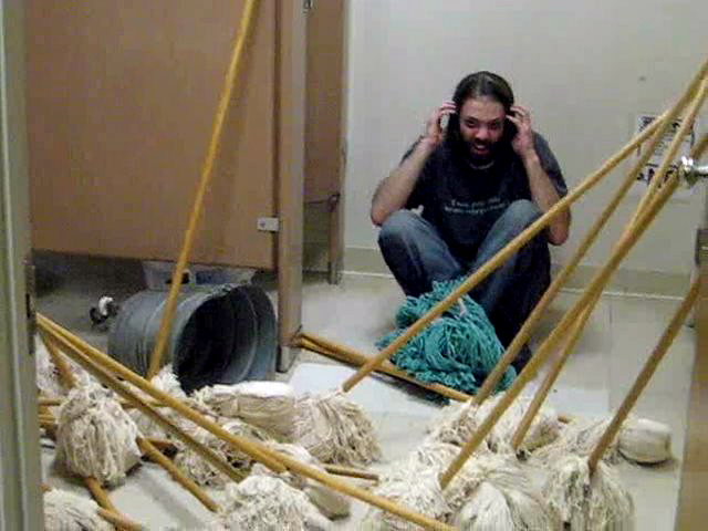 Man surrounded by mops.