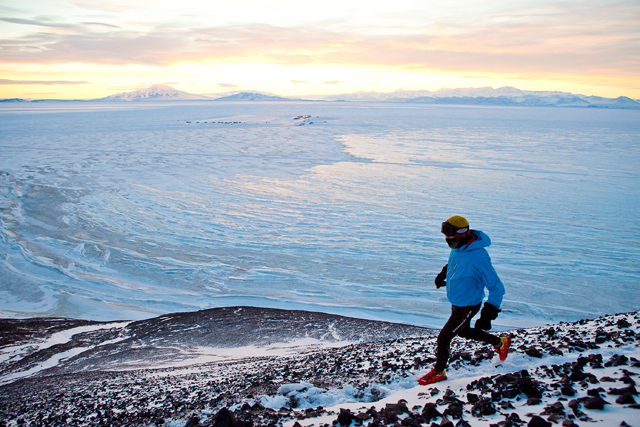 Person runs on trail above sea ice.