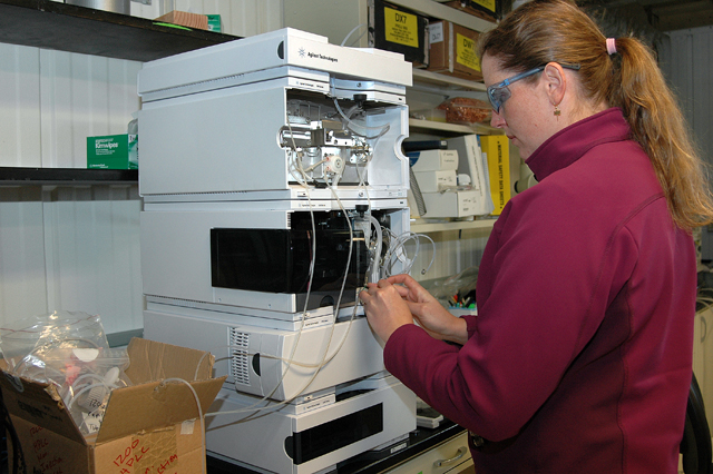 Technician fixes instrument in lab.