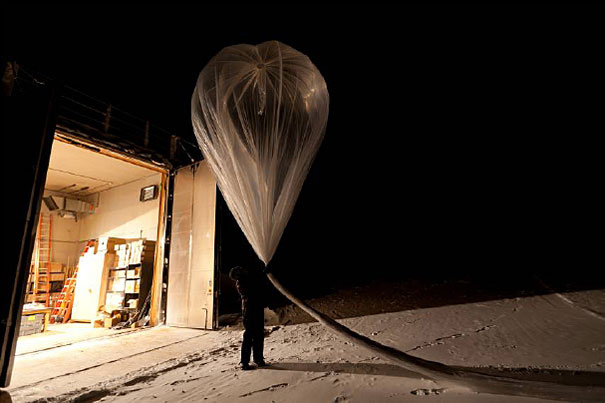 Person prepares to launch balloon at night.