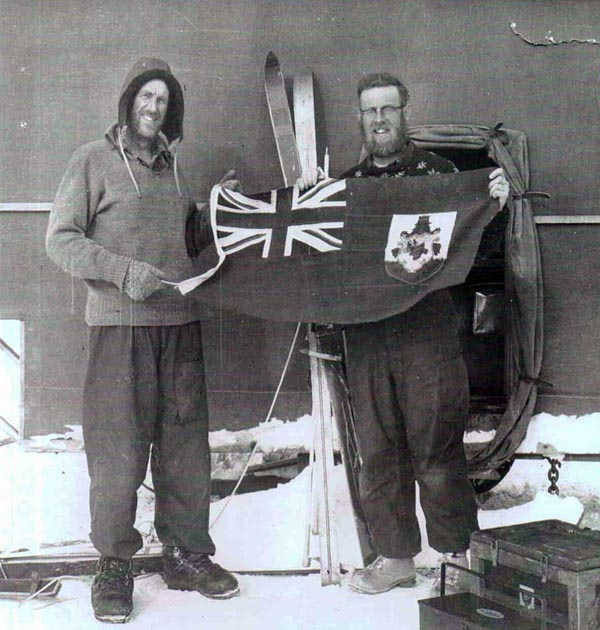 Two men hold up a flag.