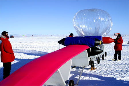 People inflate a balloon on ice.