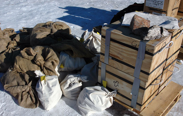 Bags and boxes sit on snow.