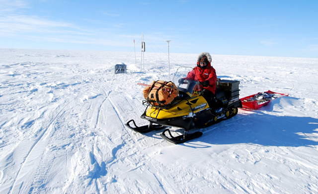 Scientist rides on a skidoo.