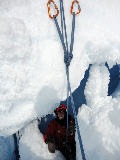 Person climbing into ice cave.