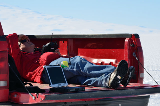 Person reclines in pickup truck bed.