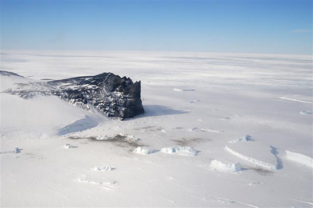 Large rock outcrop surrounded by ice.