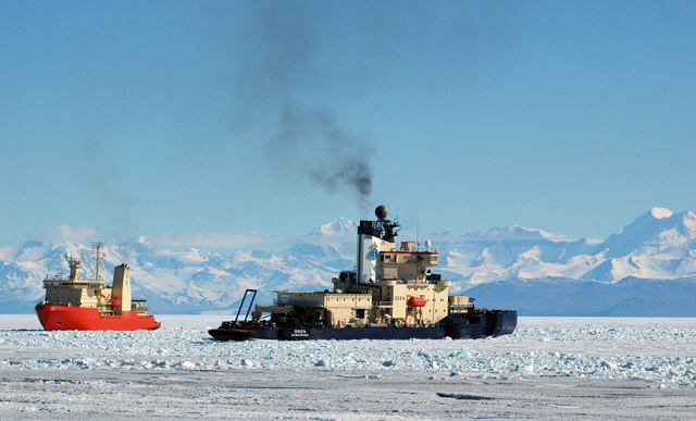 Two ships move through sea ice.