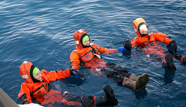 People in orange suits float in water.