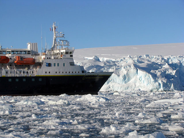 Ship moves through icy sea.