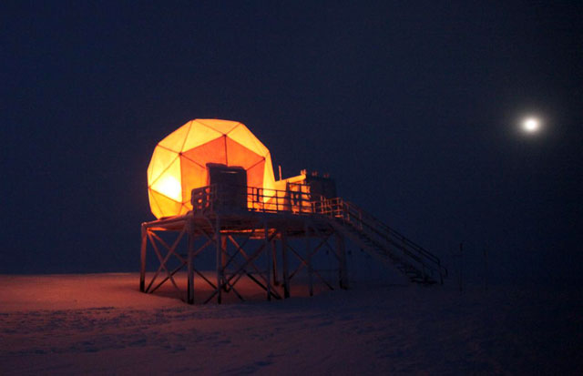 Dome lit up under night sky.