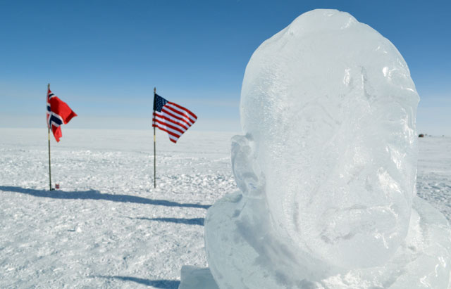Head made out of ice in front of flags.