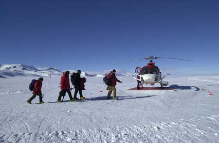 People walk toward helicopter.