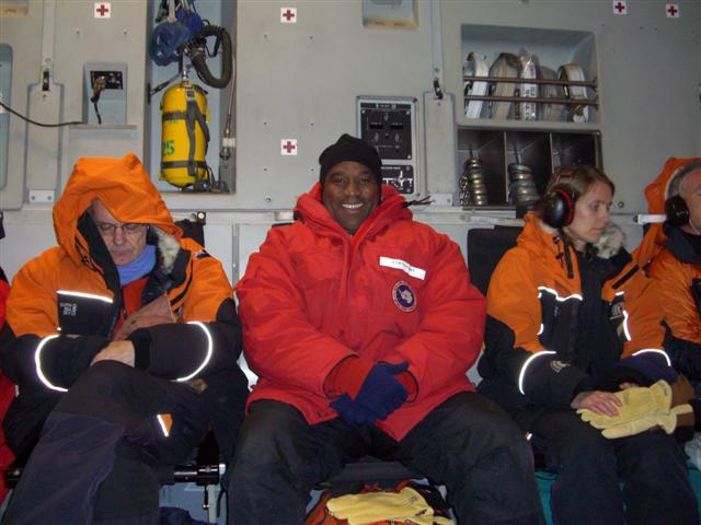 People in heavy coats sitting in aircraft.