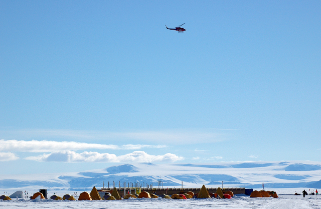 Helicopter flies over camp.