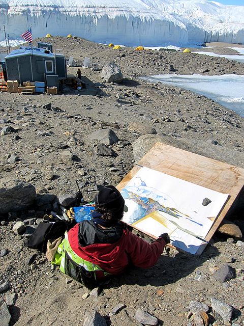 Woman drawing glacier and buildings.