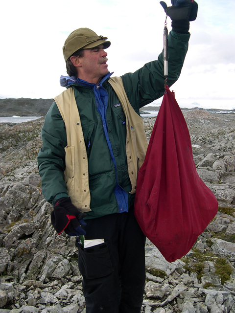 Man holds up bag and scale.