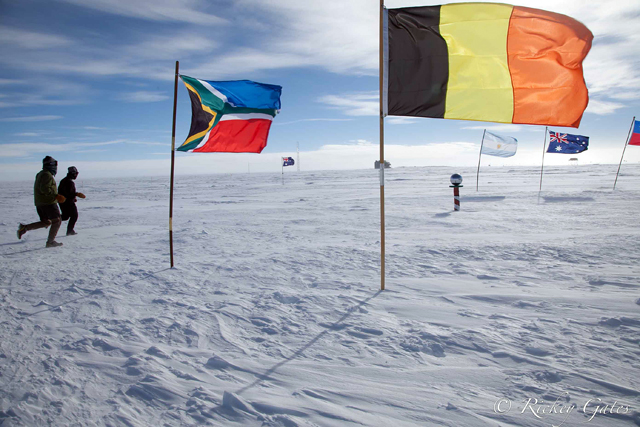 People run near flags on snow.