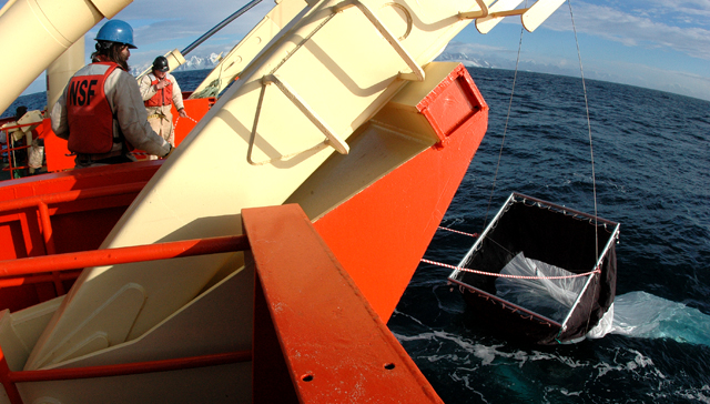 Ship personnel deploy a net off the Gould.
