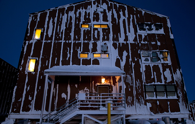 A dorm bulding covered in ice and snow.