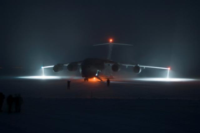 Plane on runway at night.
