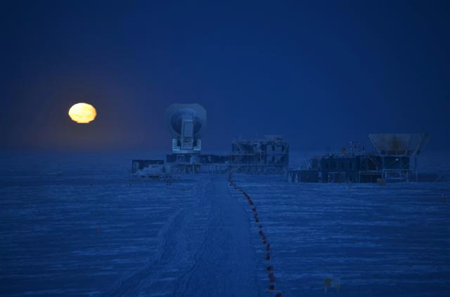 Moon rises over a telescope.