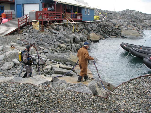 People carry hose next to water.