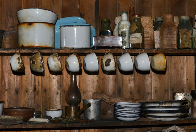 Old dishware hangs from a shelf.