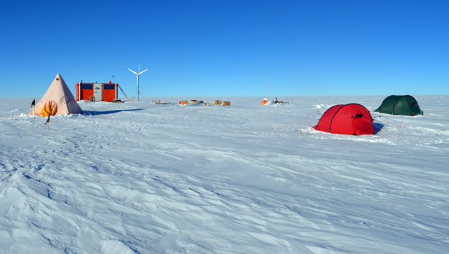 Tents and orange building on snow.