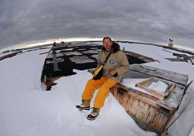 Person sits on building buried in ice.