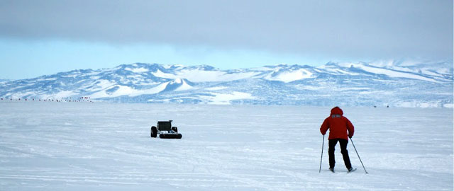 Person skis after rover headed toward mountains.