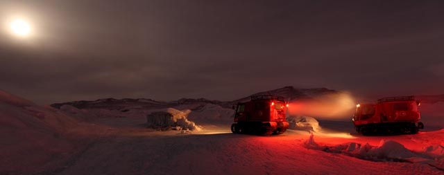 Tracked vehicles move through winter landscape.