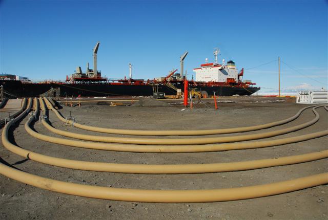 Lines of hose laid out in front of ship.