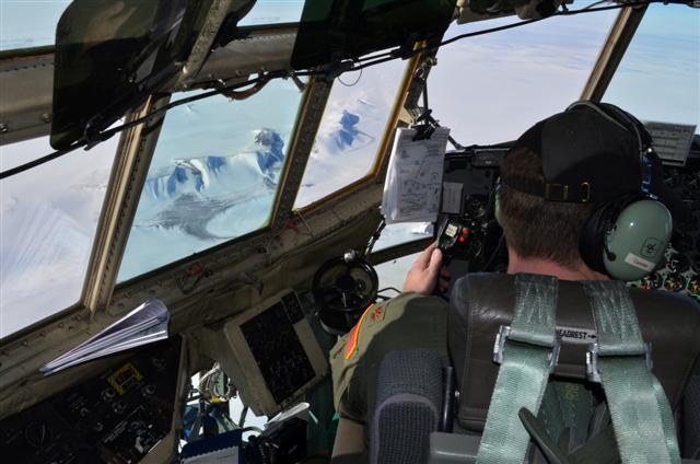 Cockpit view of snow-covered mountains.