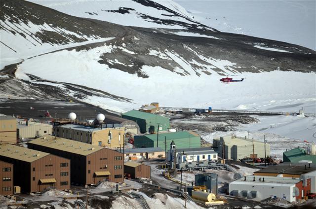 A helicopter flies over a small town.