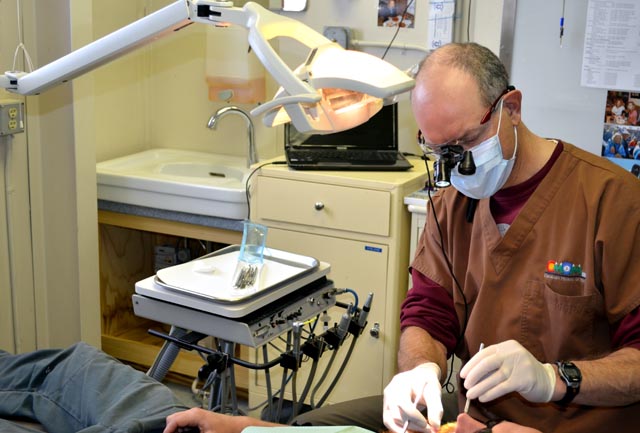 Dentist performs dental work. 