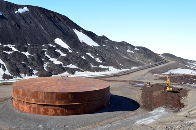 Rust-colored fuel tank sits near side of hill.