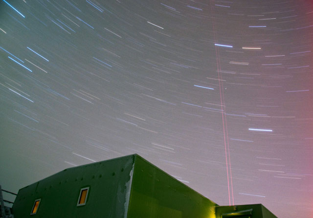 Laser shoots out of building during night.