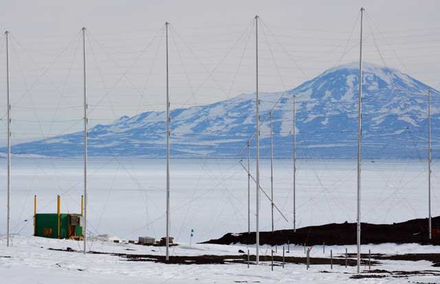 Row of antennas with mountain in background.