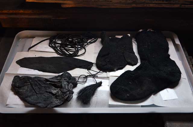 Tattered pieces of clothing sit in a tray.