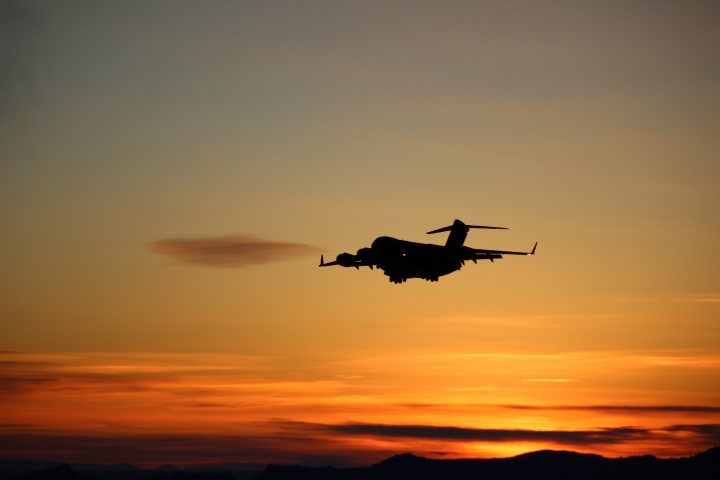 Plane flies during twilight.