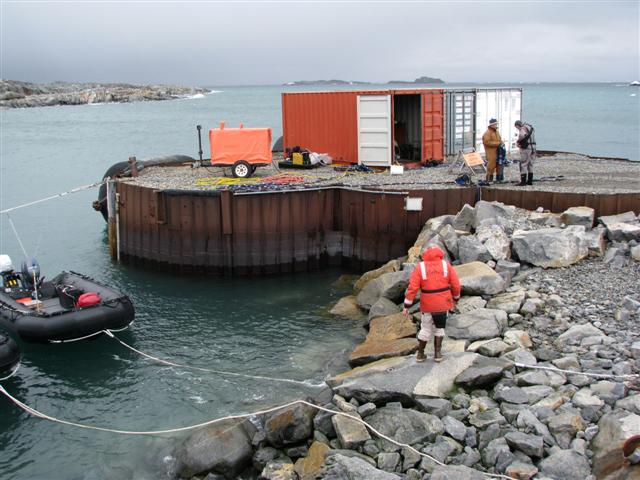 People stand near a pier.