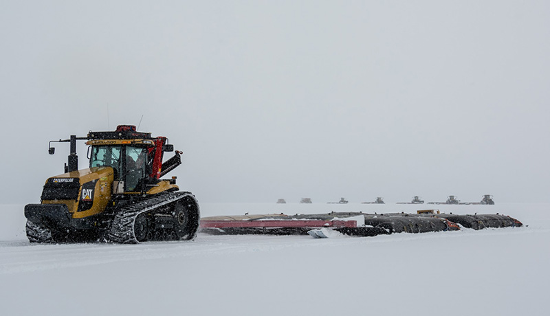 A tractor lugging fuel bladders rounds a corner shortly after leaving McMurdo Station, starting its journey of more than 1,000 miles to the South Pole.