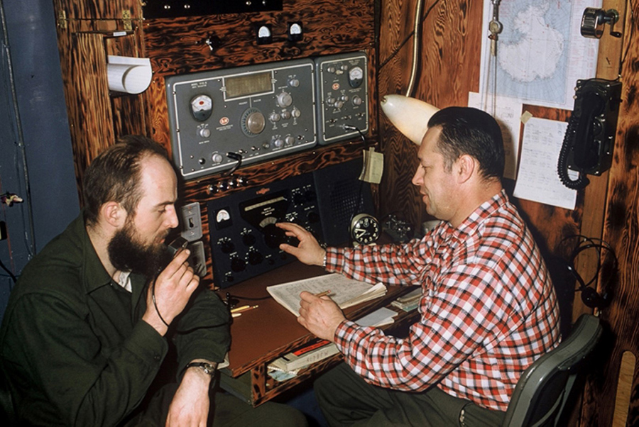Charles Bentley, left, uses a ham radio while sitting next to station leader Steve Barnes at Byrd Station