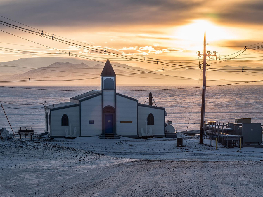 The sun sets behind McMurdo Station's Chapel of the Snows