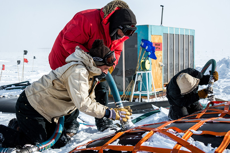 (Left to Right) Ben Eberhardt, Tim Mullen and Jarred (Red) Taylor hook up fuel lines to fuel bladders at the South Pole.